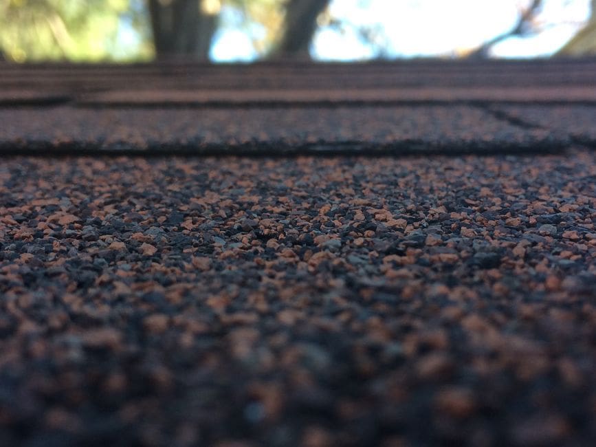 Close-up of asphalt shingle wear noted in a roof inspection