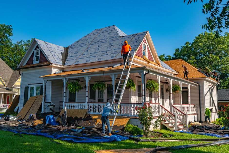 Shingle tear-off during a permitted roof replacement on a Texas home