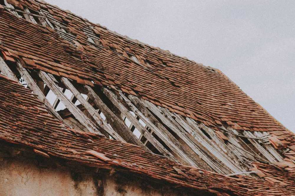 Close-up of worn asphalt shingles with granule loss and aging, typical roof wear not hail damage