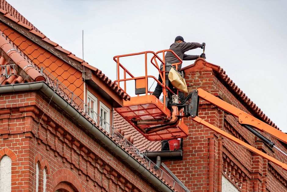 Roofer inspecting a roof for hail damage after a North Texas storm